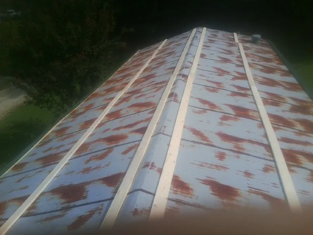 Rusted metal roof panels with new wood purlins before replacement — Storm Damage Roof Repair in Harveysburg by Roofing Brothers