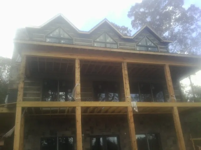 Dormers and porch framing on a large log home under construction — Roof Coating work by our crew in Harveysburg
