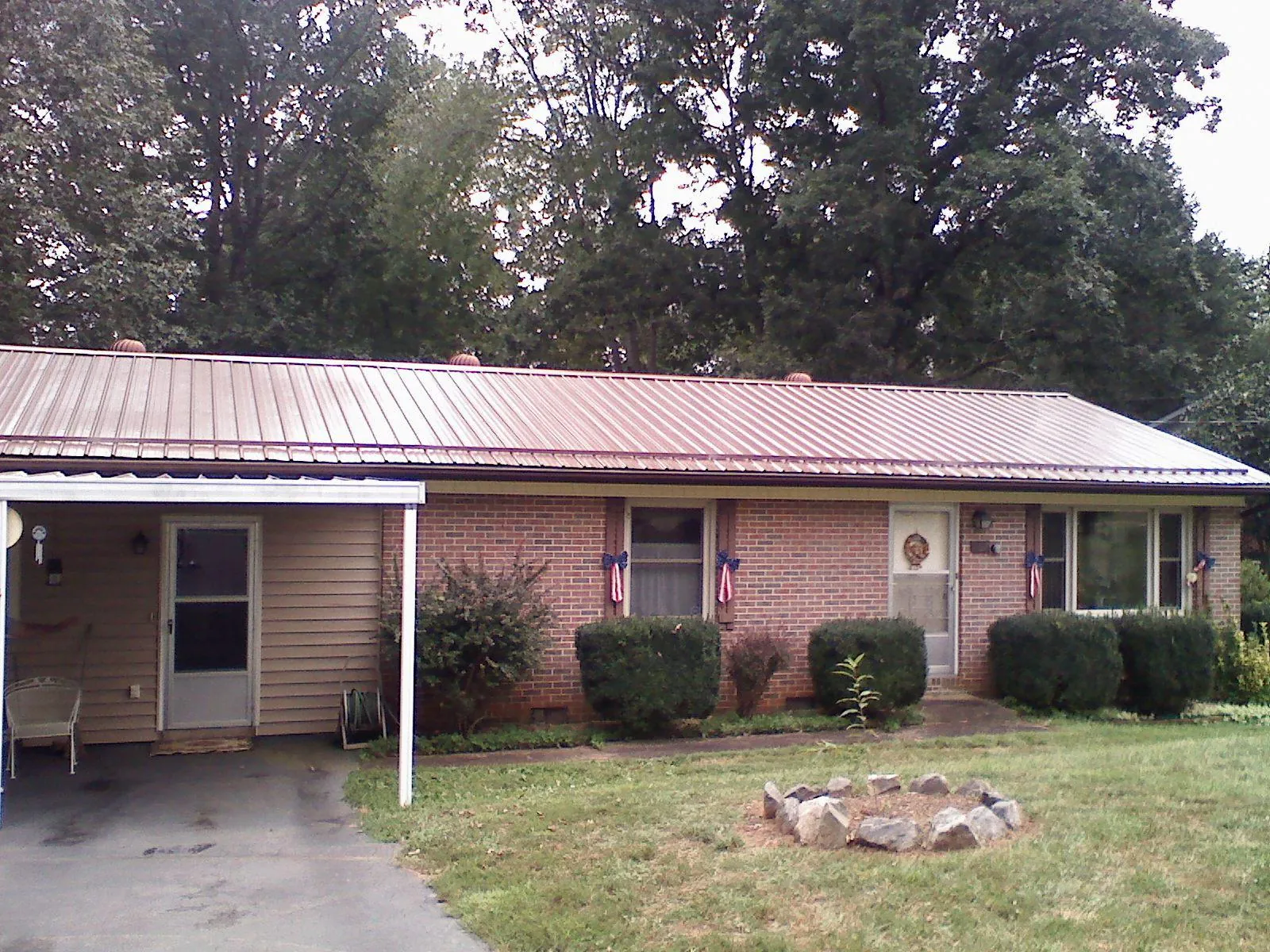 Bronze metal roof and carport on a brick ranch home — Roof Repair work by our crew in Harveysburg